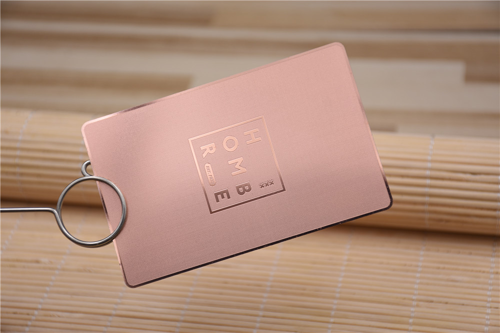 Rose gold metal card, linen background, glossy rose gold logo and border